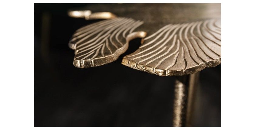 Zoom sur les détails rayés de la table basse avec plateau en forme de feuille dorée METRIX