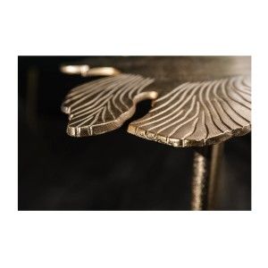 Zoom sur les détails rayés de la table basse avec plateau en forme de feuille dorée METRIX
