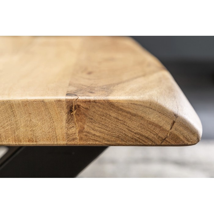 Zoom sur la tranche du plateau de la table basse ARKAYA en acacia 110cm avec pieds en forme de X noirs