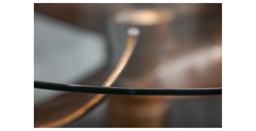 Zoom sur le plateau de verre de la table ALUMIA bronze