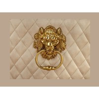 Zoom sur la tête de lion de la chaise REGINA beige et dorée